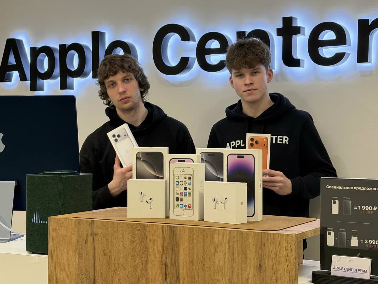 Два человека с техникой у прилавка Apple Center